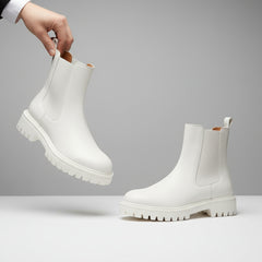 White boots with brown soles on a beige background