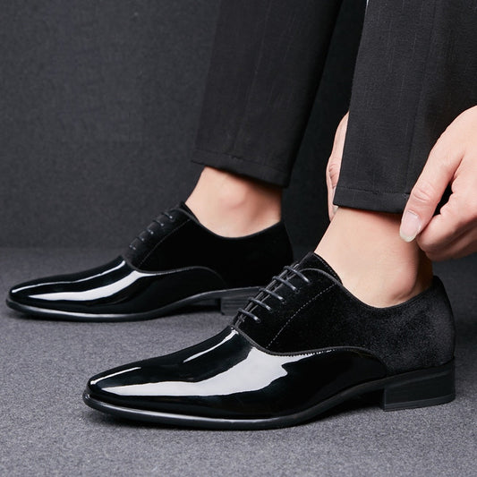 Black dress shoes being worn on a gray background