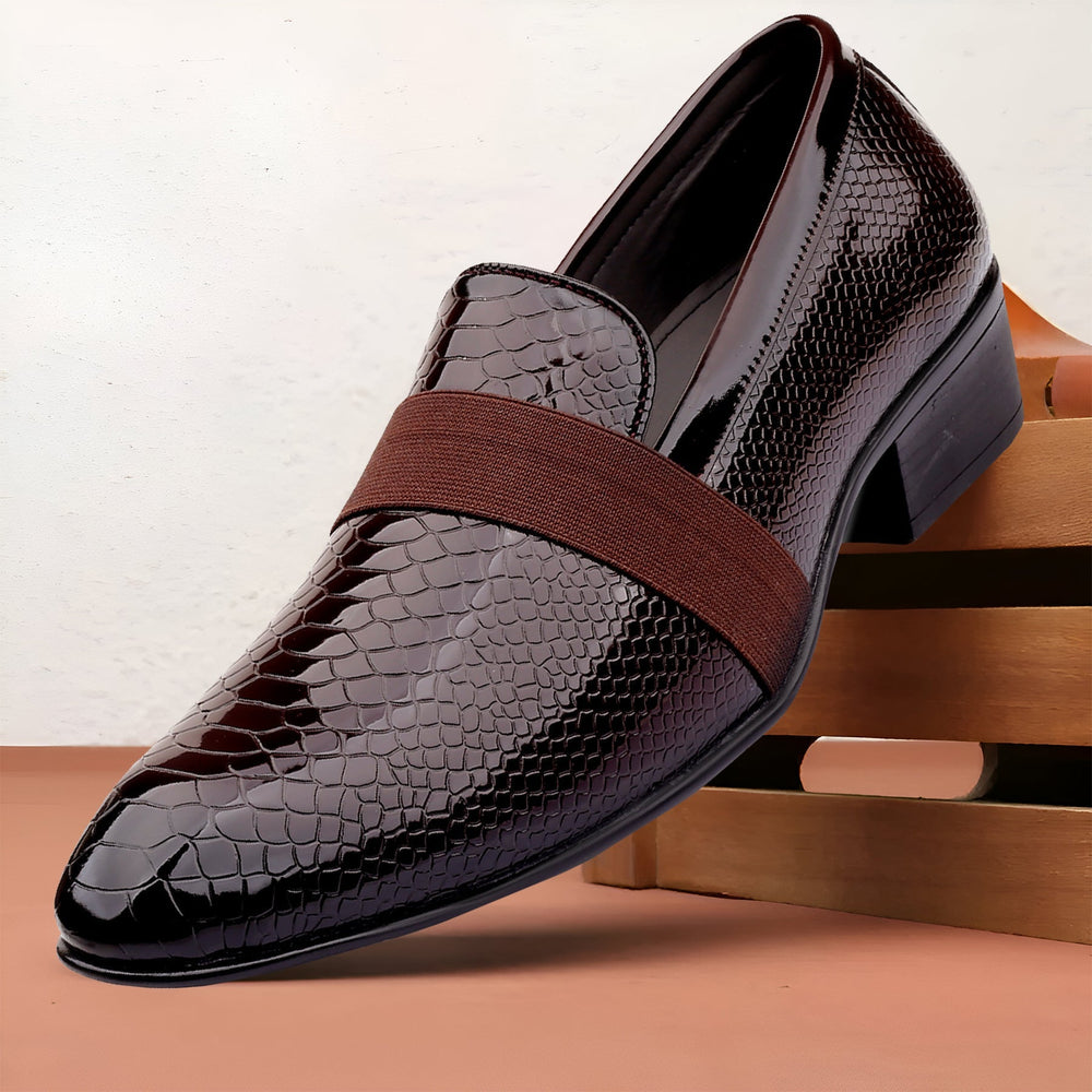 Brown leather dress shoe with a brown strap on a wooden surface