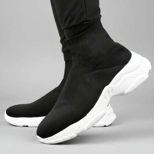 Black sock shoes with white soles worn by a person on a dark background