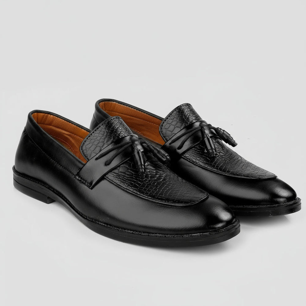 Pair of black leather loafers with tassels on a white background