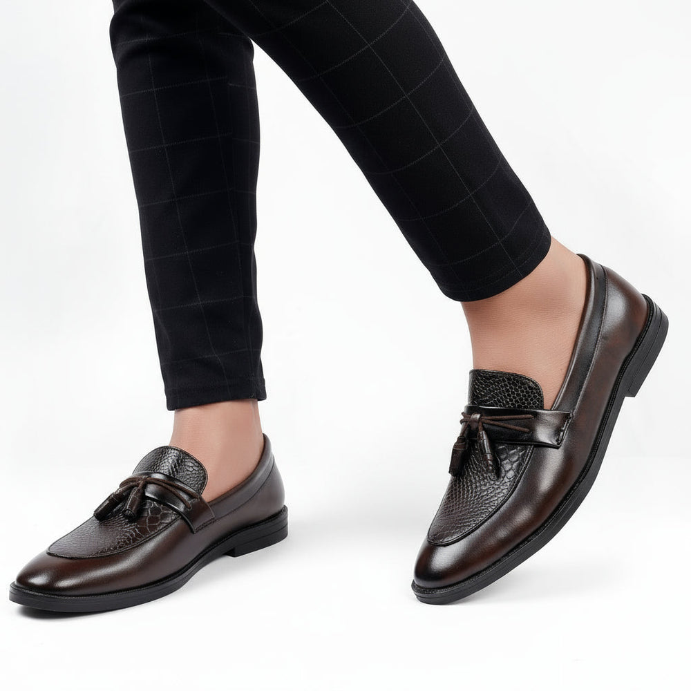 Brown leather loafers worn with black checkered pants on a white background