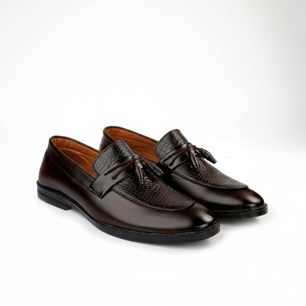 Pair of brown leather loafers with tassels on a white background