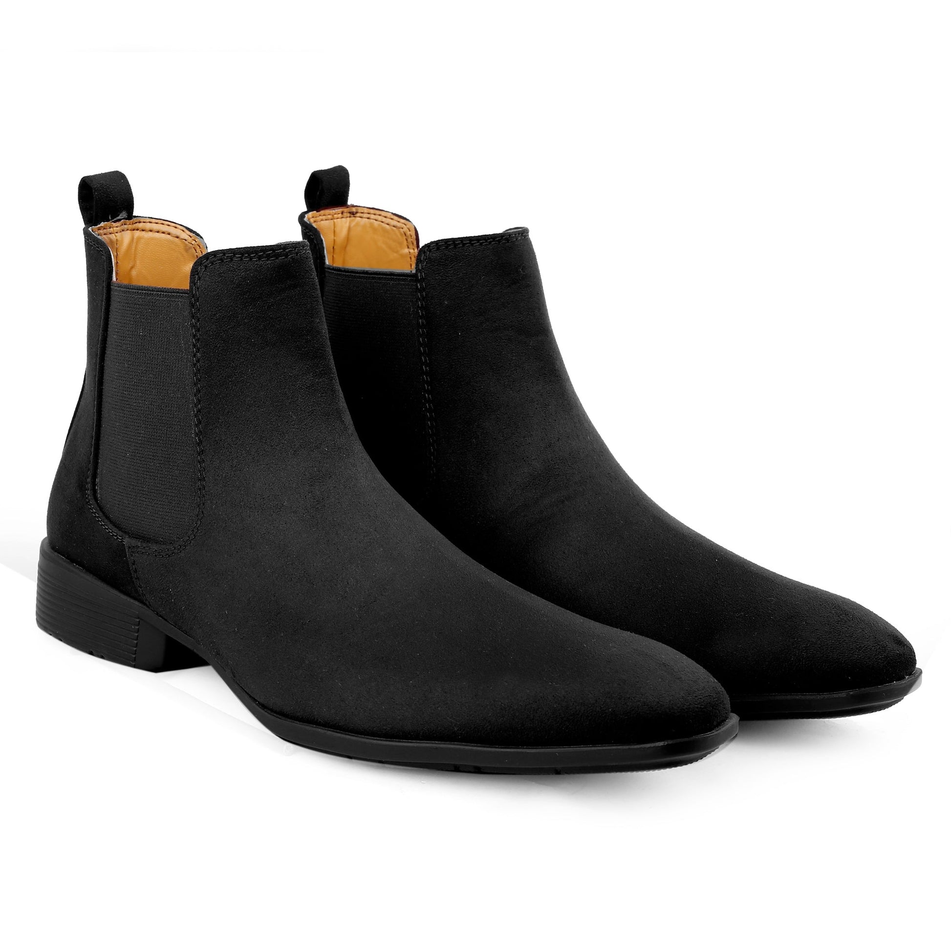 Pair of black Chelsea boots with tan interior on a white background