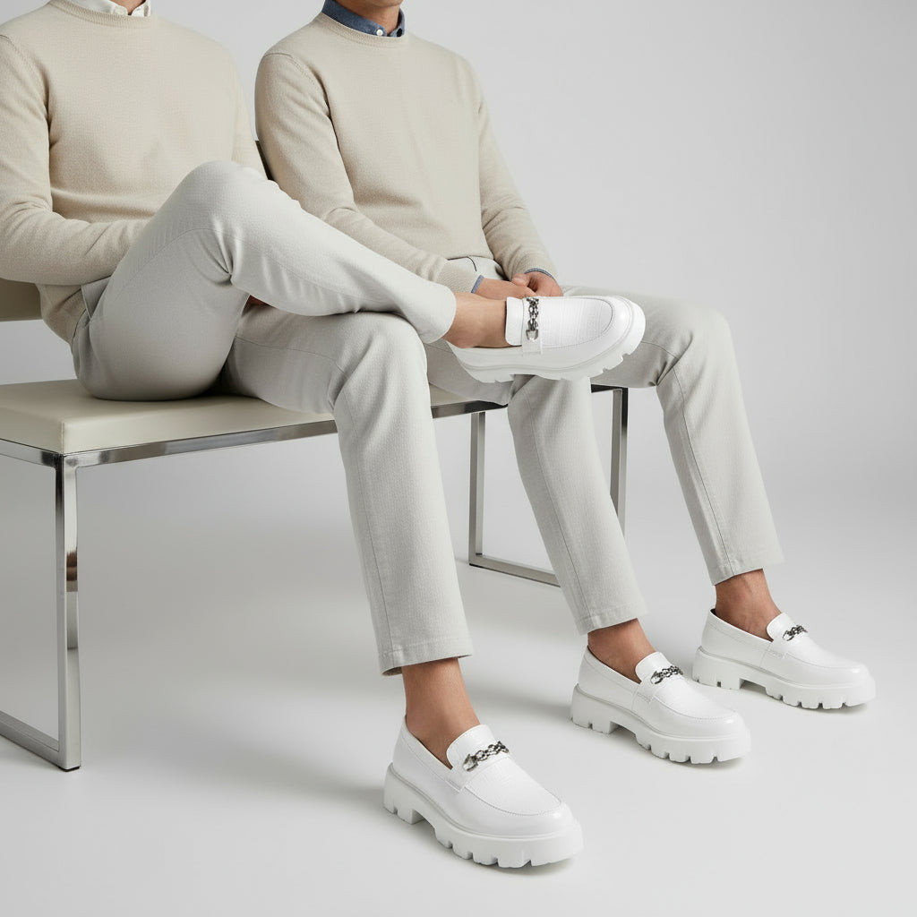 White loafers with chunky soles on a gray and beige background, featuring the Buxy brand.