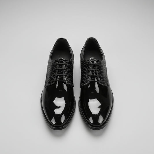 Black patent leather shoes on a wooden floor