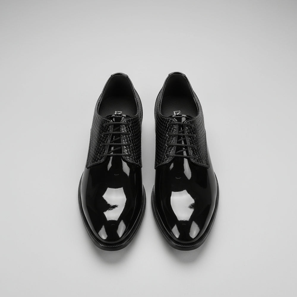Black patent leather shoes on a wooden floor
