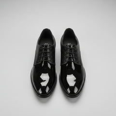 Black patent leather shoes on a wooden floor