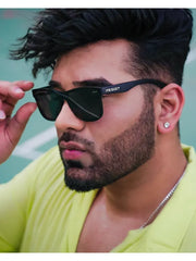 Man wearing black sunglasses with a brand logo, green shirt, and earring.
