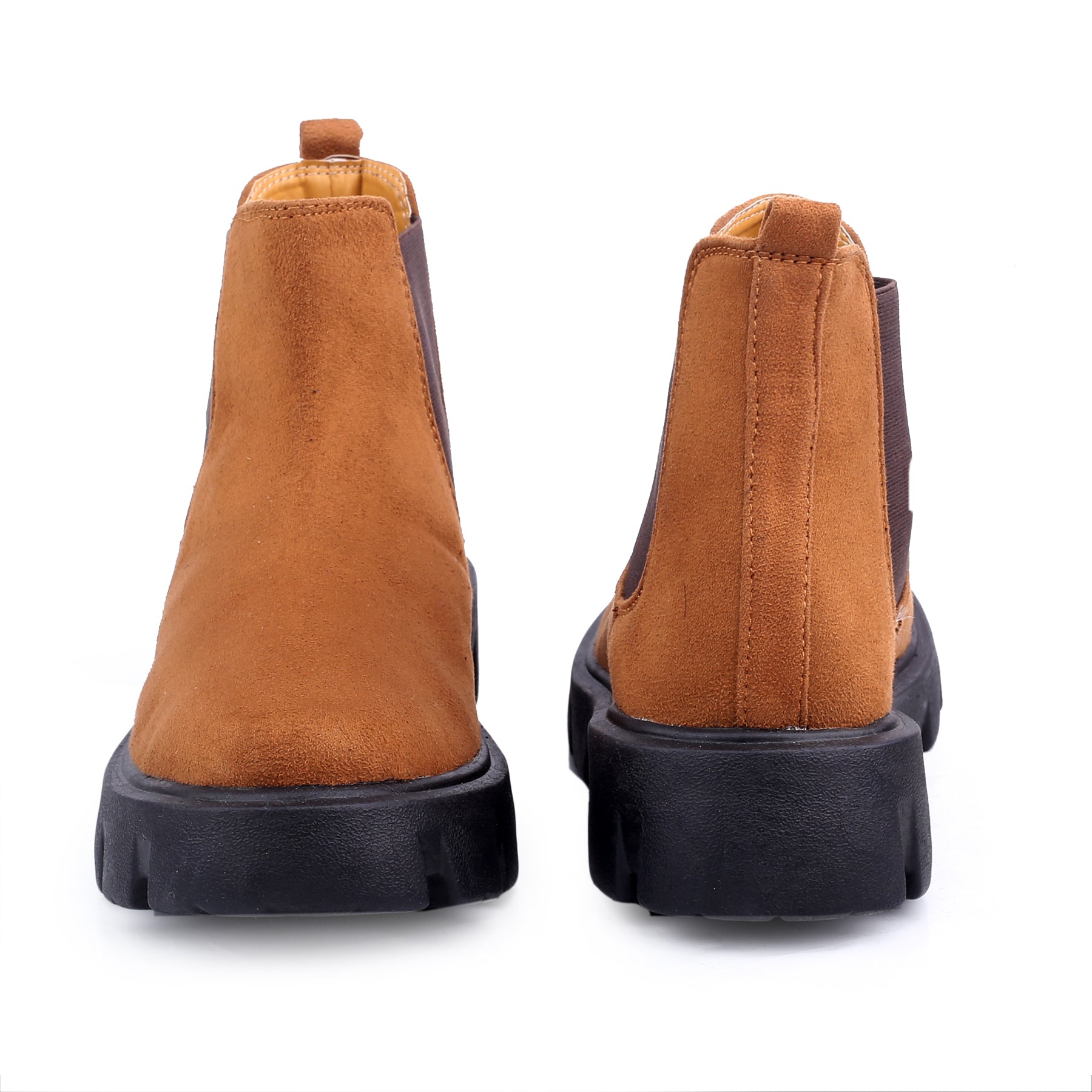 Pair of brown boots with black soles on a white background