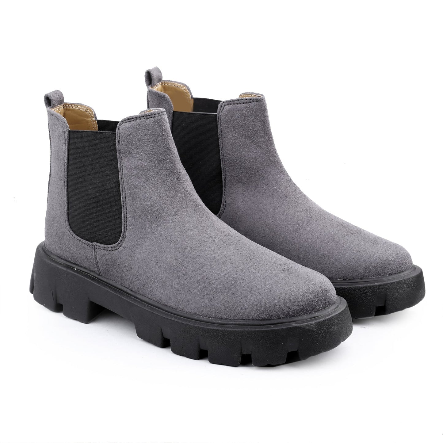 Pair of gray suede Chelsea boots with black soles on a white background