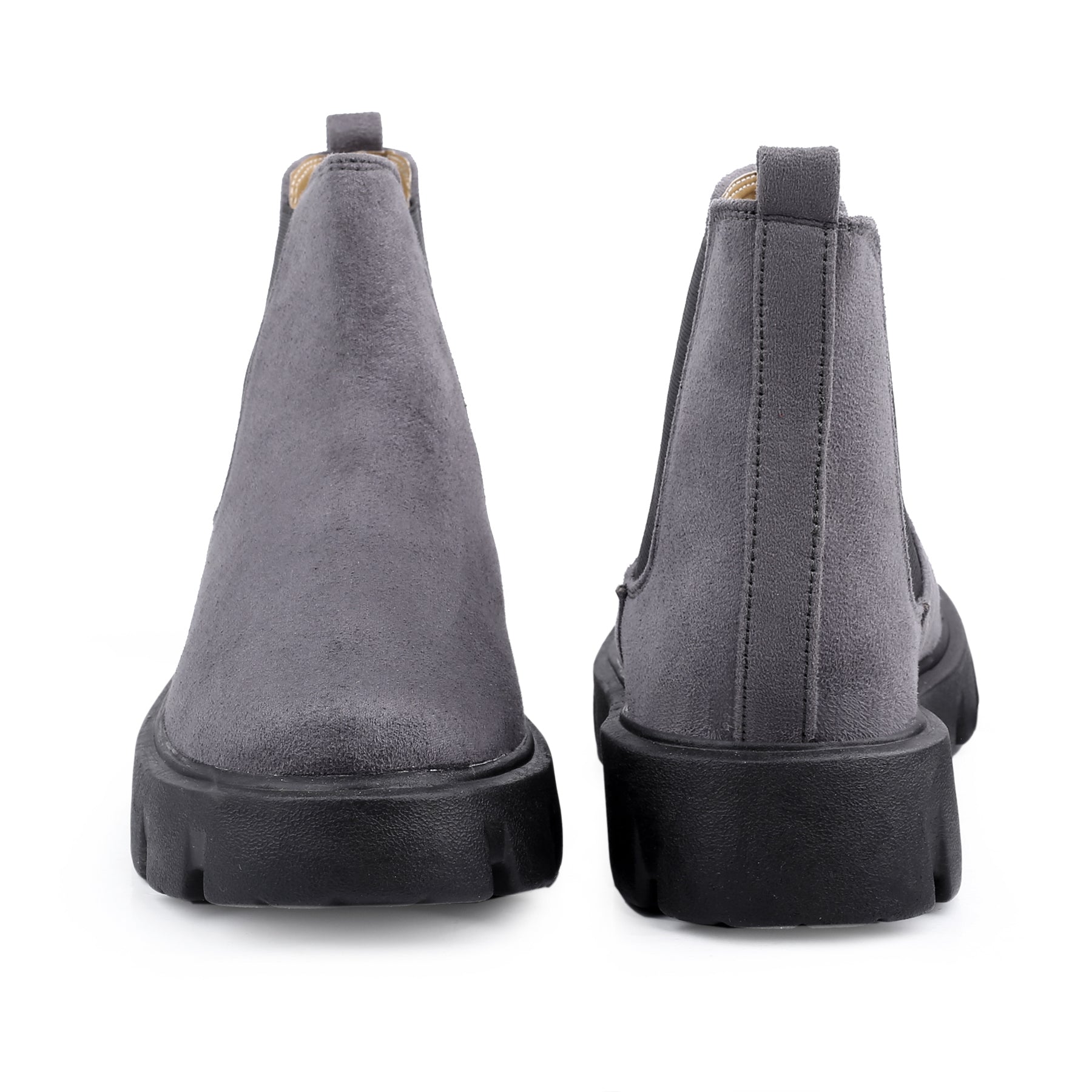 Gray suede boots with black soles on a white background