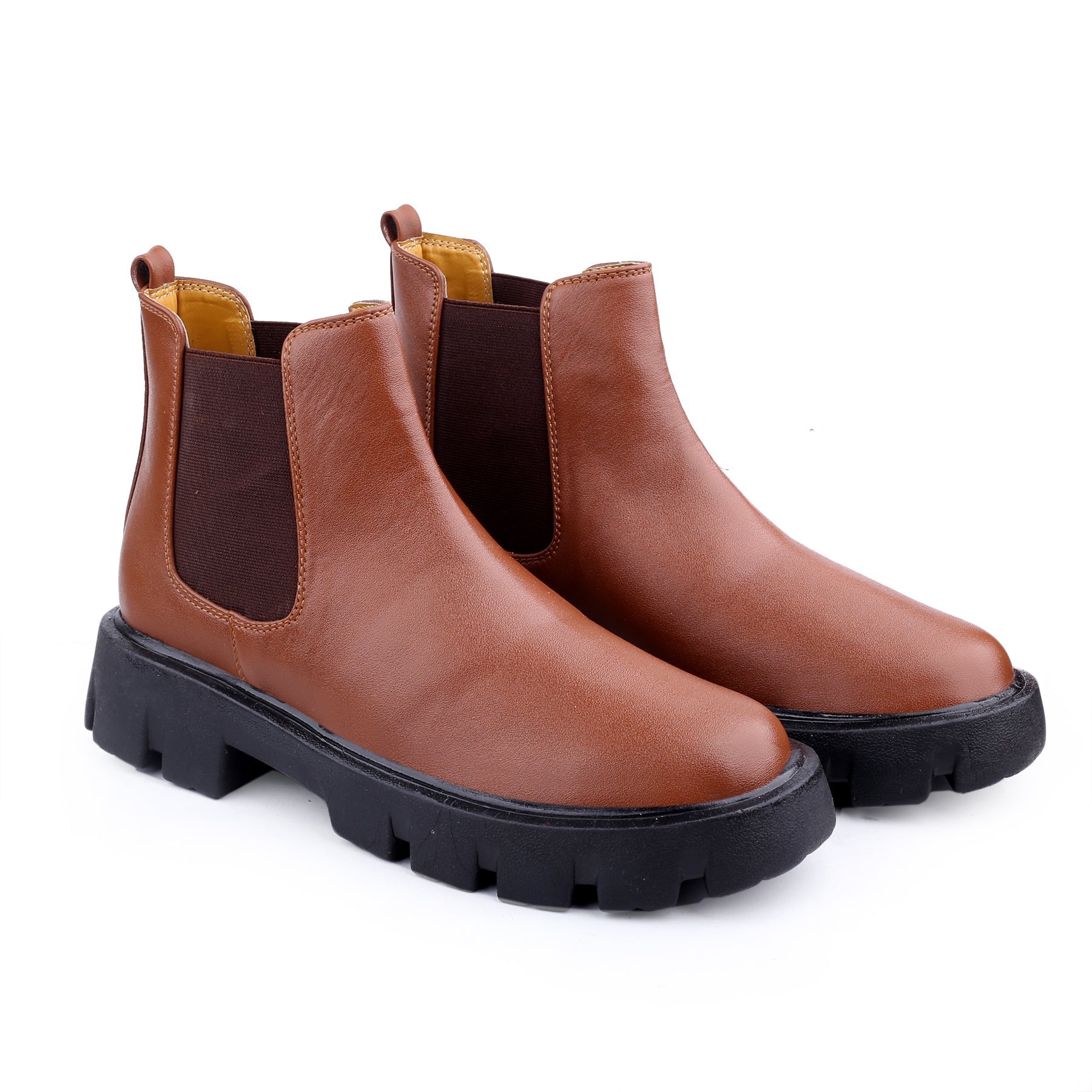 Pair of brown leather boots with black soles on a white background