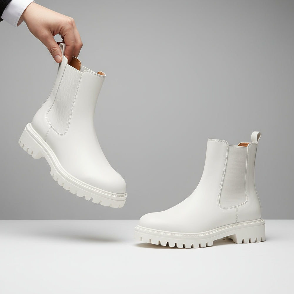 White boots with brown soles on a beige background