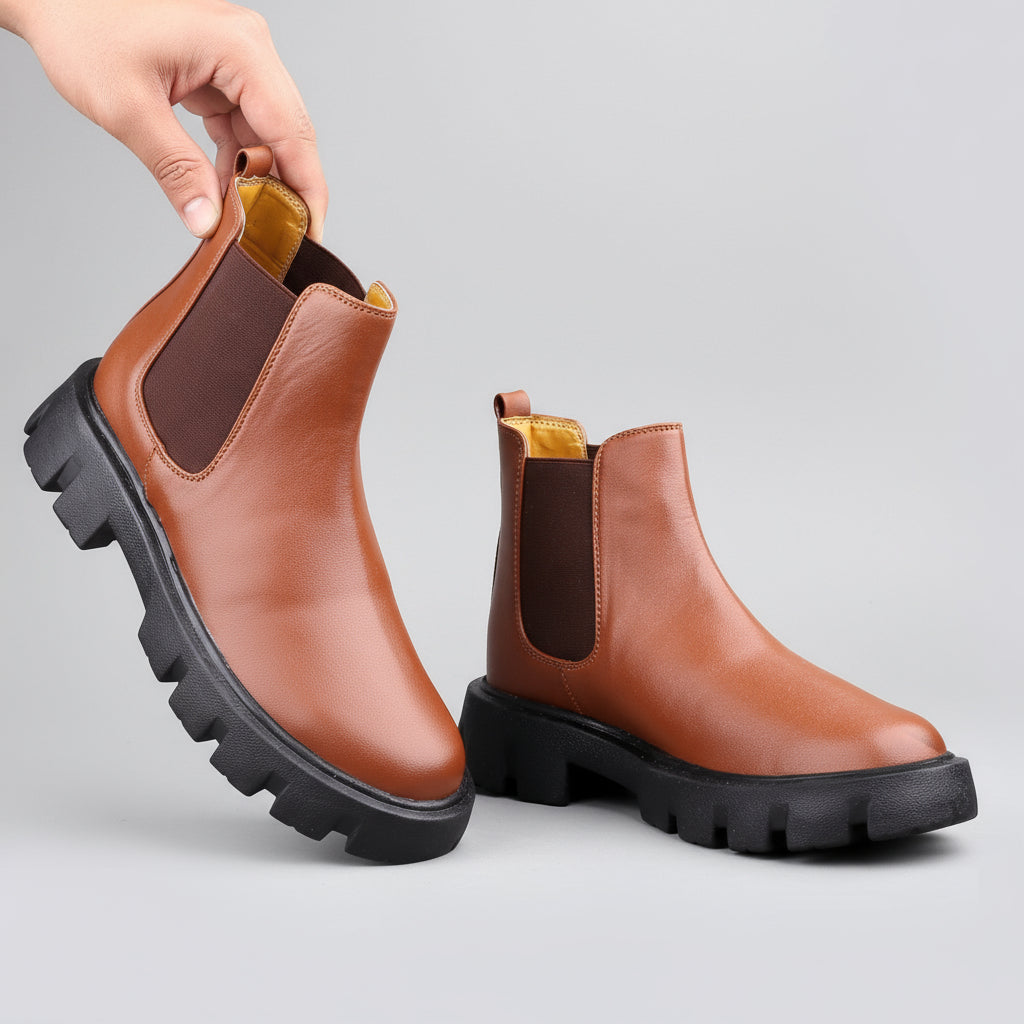 Brown leather boots with black soles on a beige background