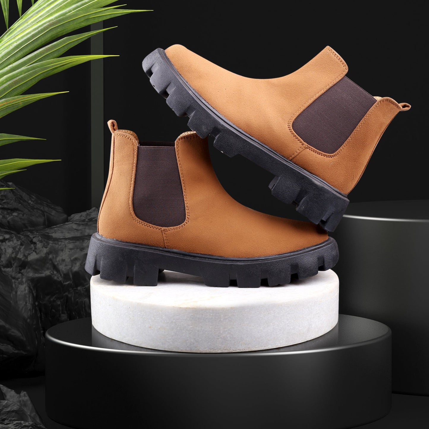 Pair of brown boots with black soles on a white cylindrical stand against a dark background.