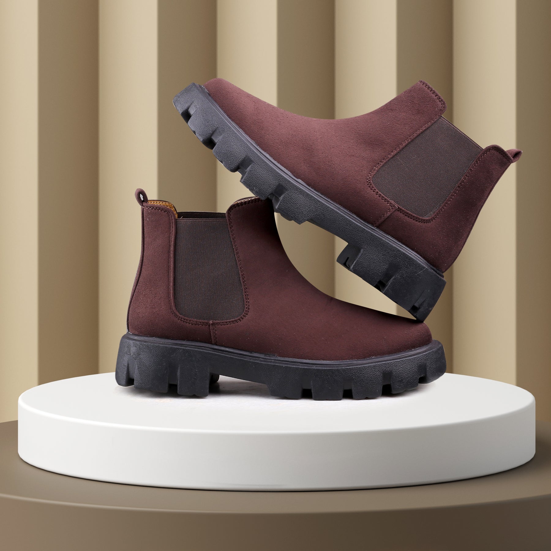 Pair of brown boots on a white platform with a striped background