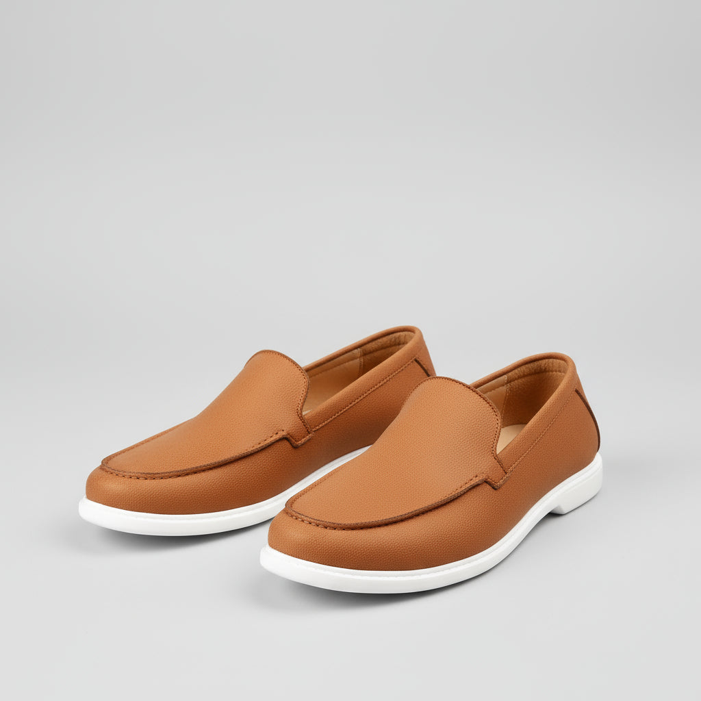 Brown loafers being worn on a light wooden floor