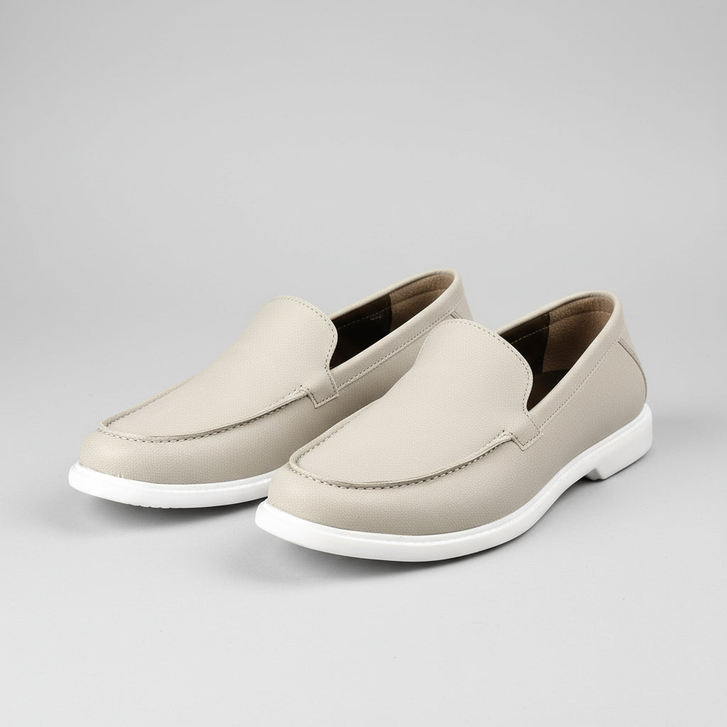 Beige loafers being worn with a brick wall background