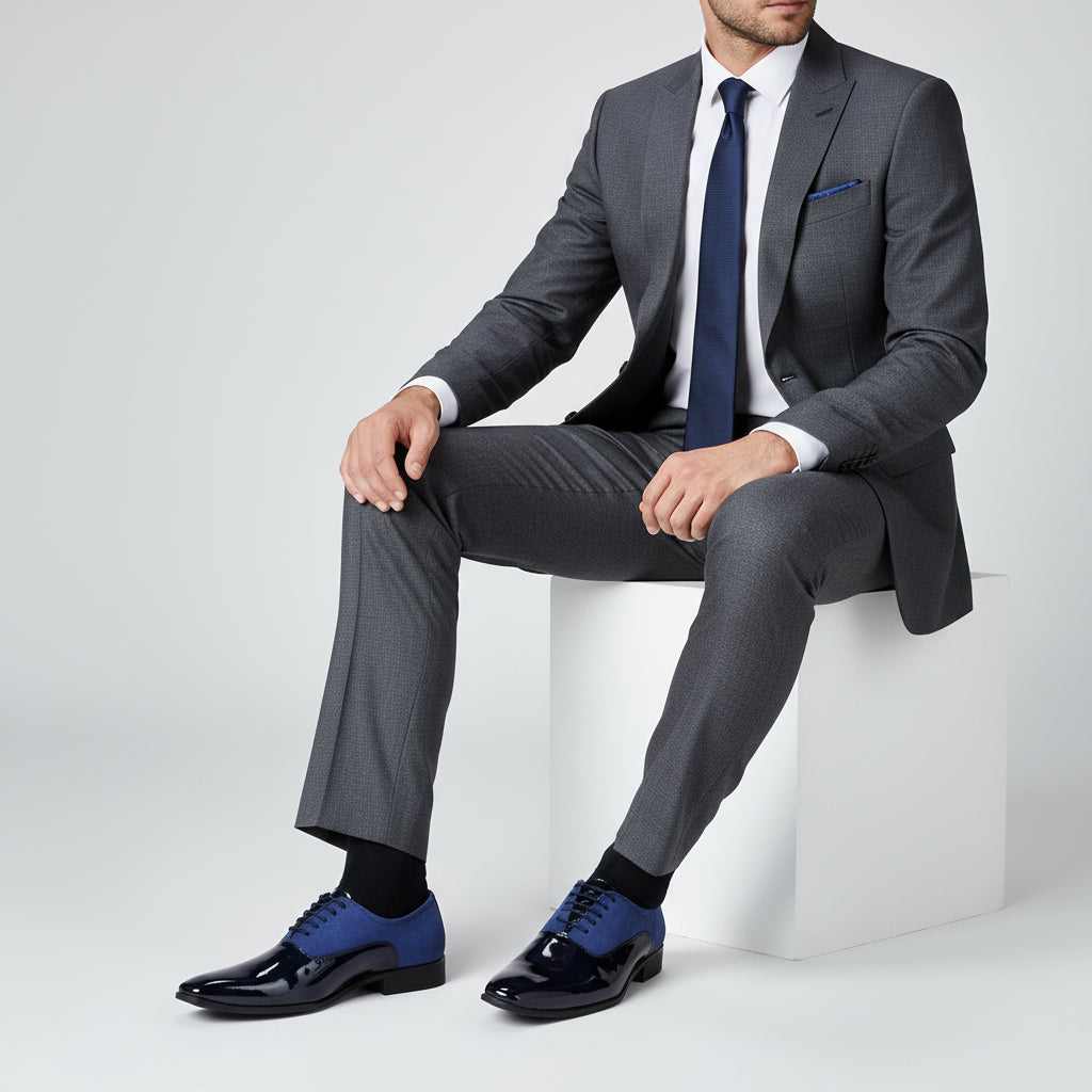 Pair of blue dress shoes with glossy finish on a white platform,