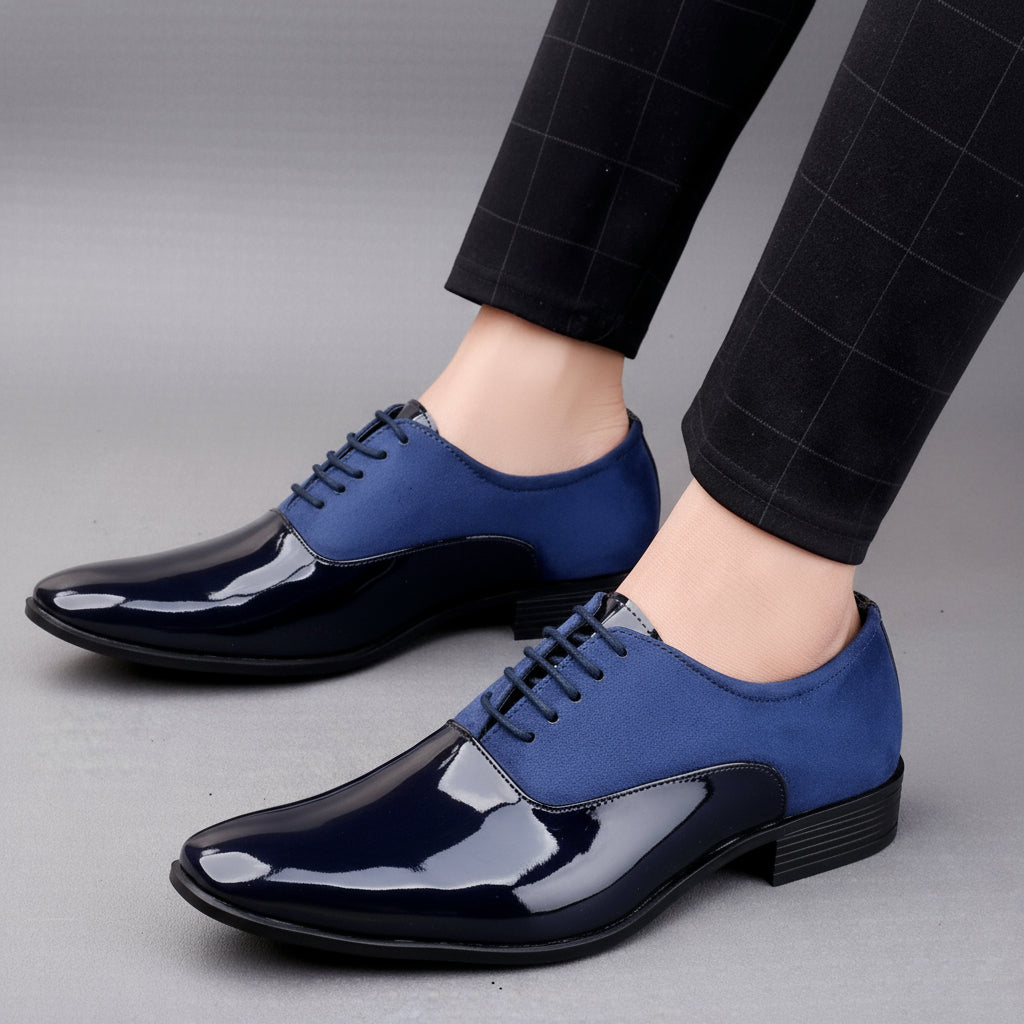 Blue and black dress shoes worn with black pants on a neutral background