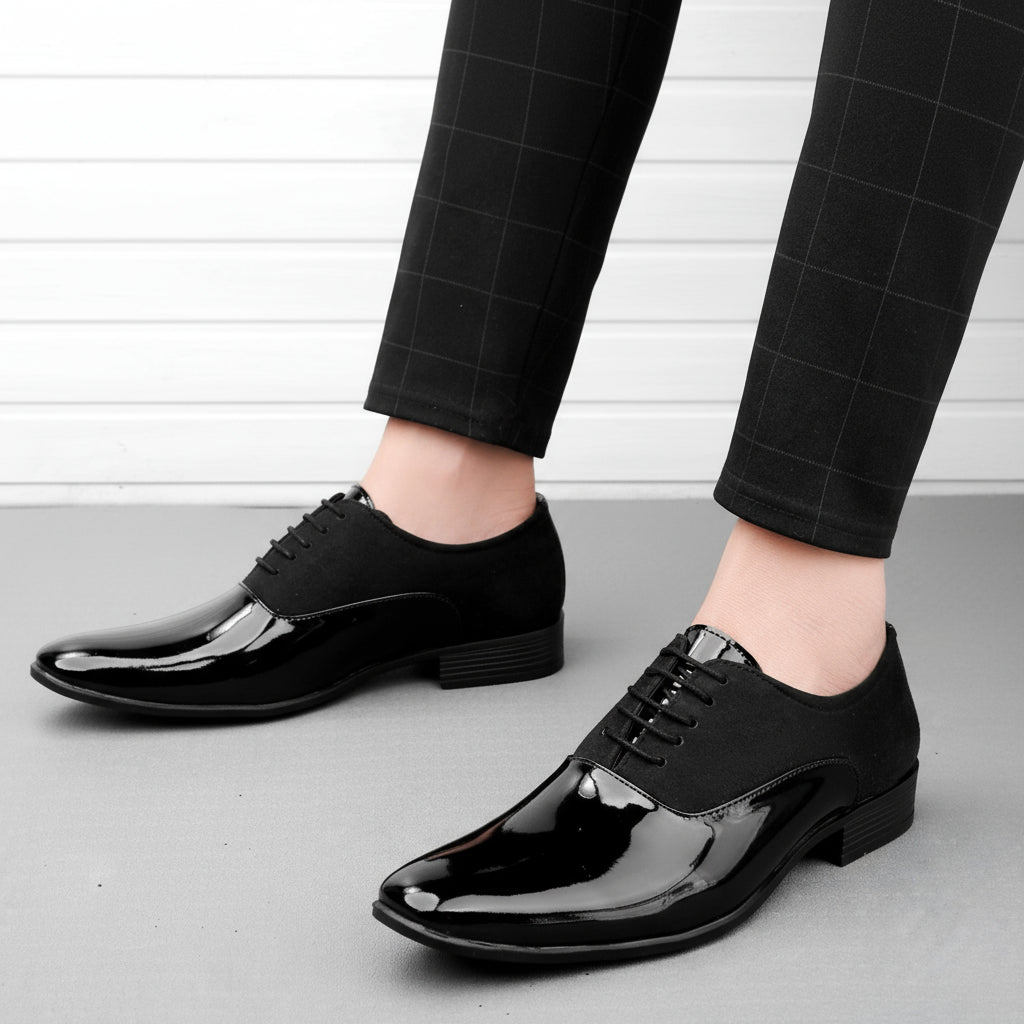 Black shiny dress shoes worn with black checkered pants on a light background