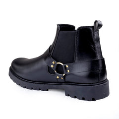 Black leather boot with gold buckle on a white background