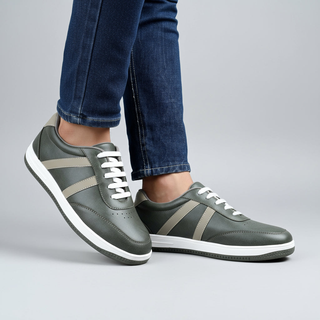 Person wearing gray sneakers with white soles on a wooden floor.