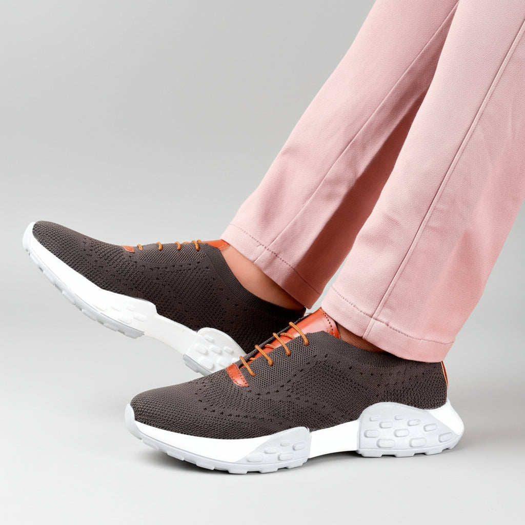 Person wearing brown sneakers with white soles on a wooden floor.