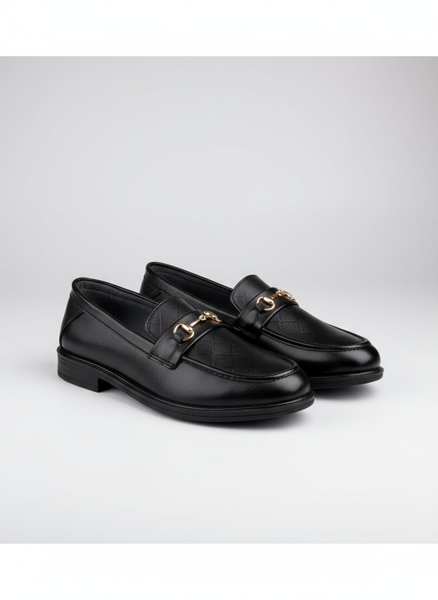 Pair of black loafers with gold buckles on a white background
