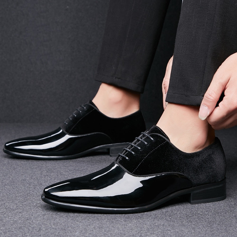 Black dress shoes being worn on a gray background