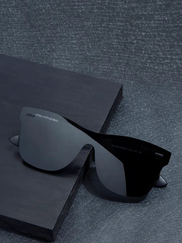 Black sunglasses with reflective lenses on a textured gray surface