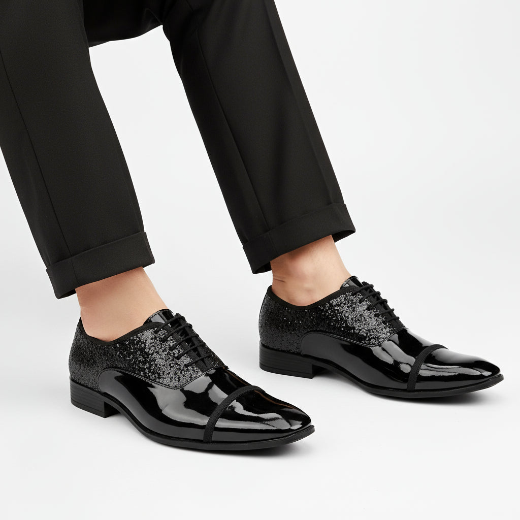 Black patent leather shoes with glittery black laces on a white background