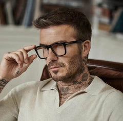 Stylish man wearing black frame blue light blocking glasses for men while sitting comfortably