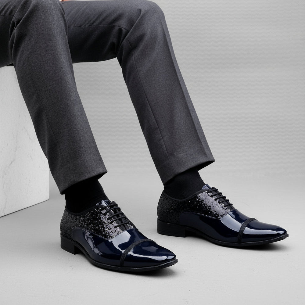 Black patent leather shoes on a white platform with a gray background