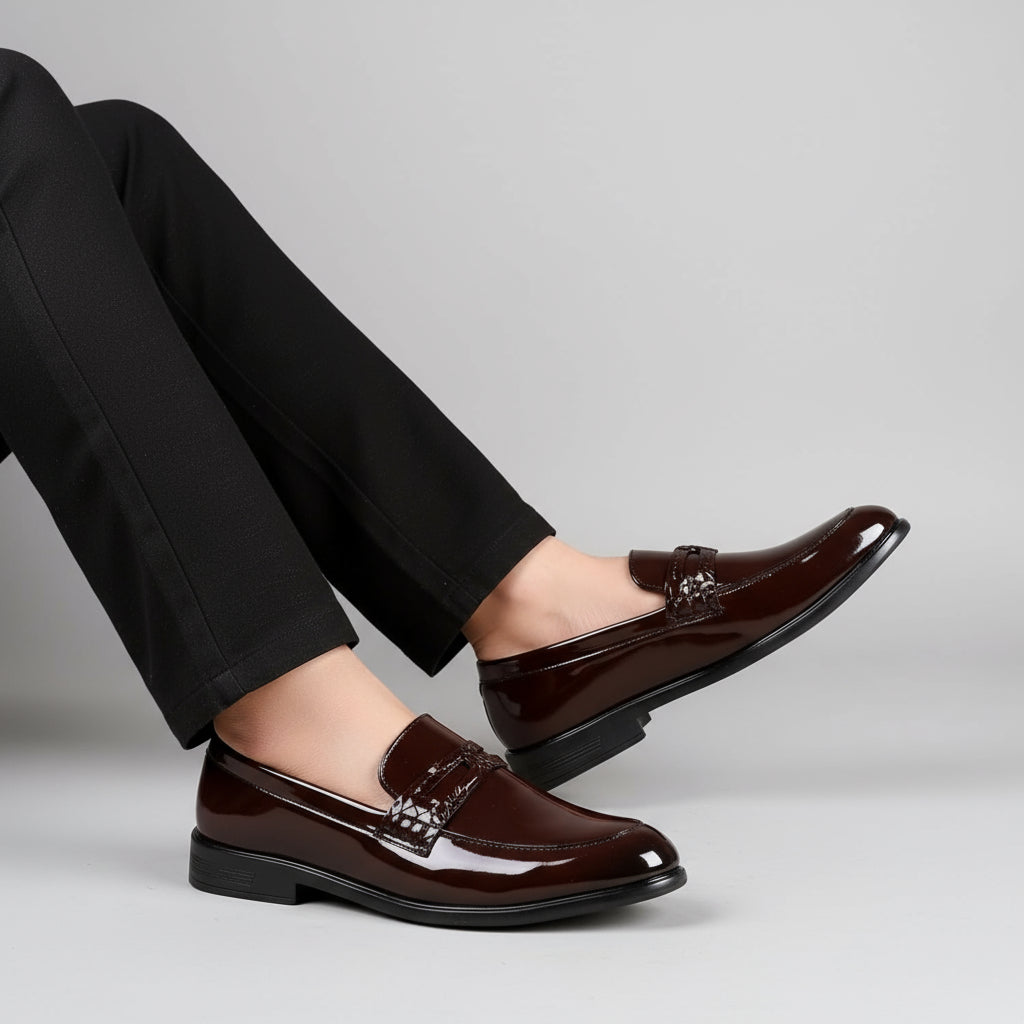 Brown dress shoes worn with black pants on a neutral background