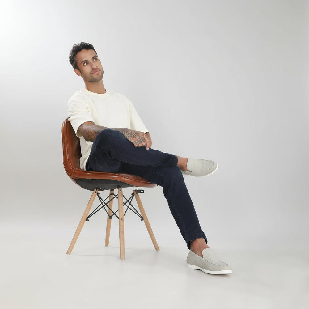 Man sitting on a brown chair against a white background